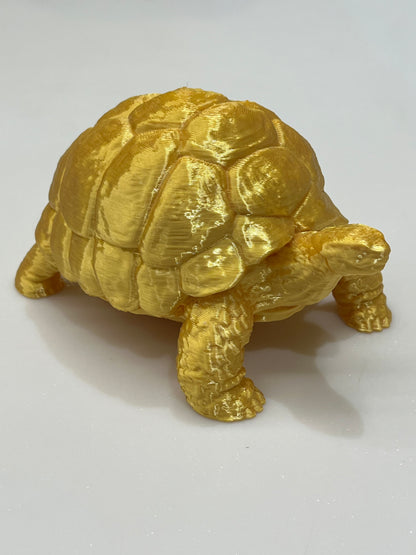 The Golden Vastu Tortoise - 5 Inch Prosperity & Stability Symbol is a gold-colored 3D-printed figurine with a detailed shell, displayed on a white background, representing prosperity and harmony as per Vastu Shastra.