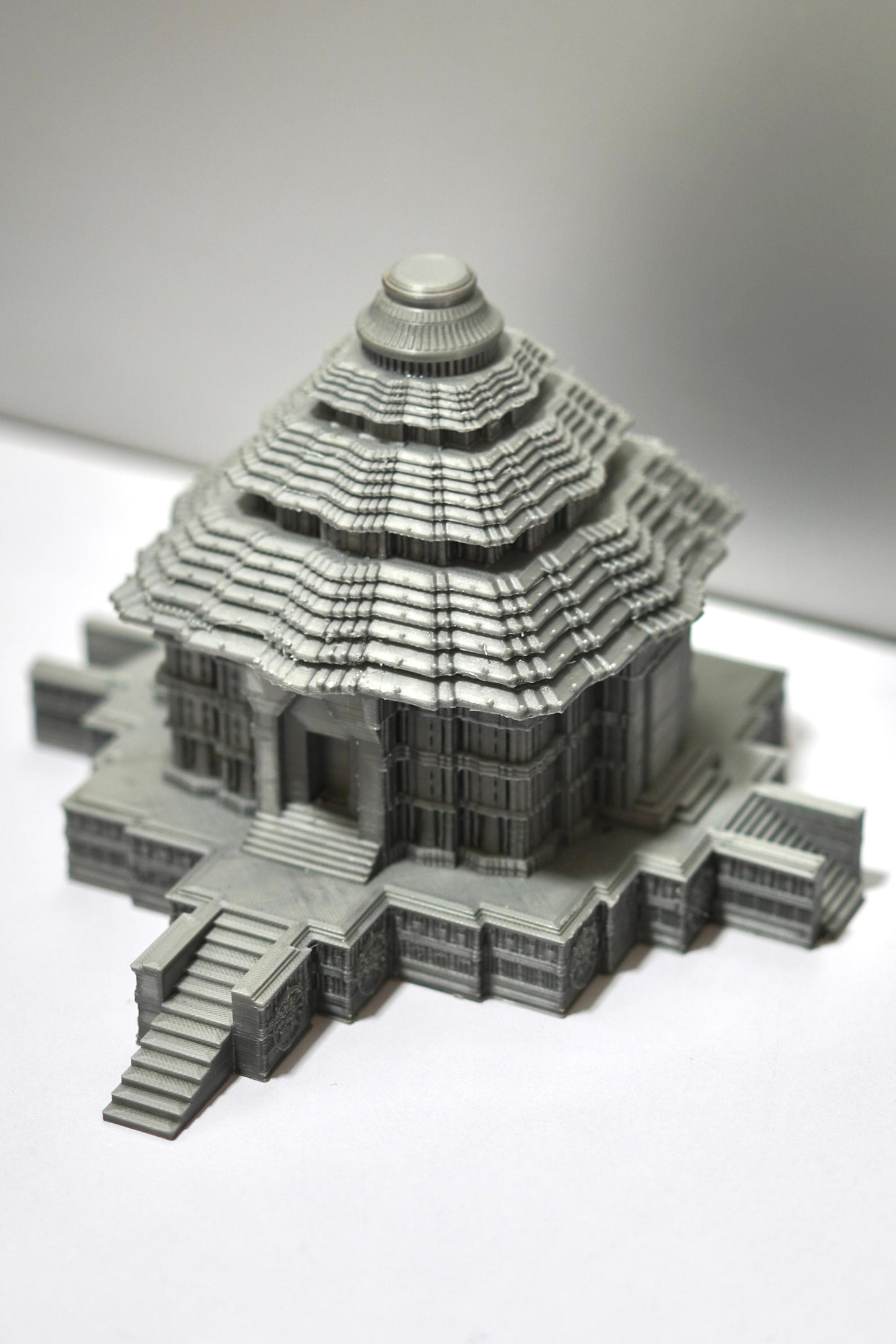 The Konark Sun Temple Sculpture is a 5.5-inch gray 3D-printed model with intricate Indian architectural details, tiered roofs, and multiple staircases, displayed on a plain white surface.