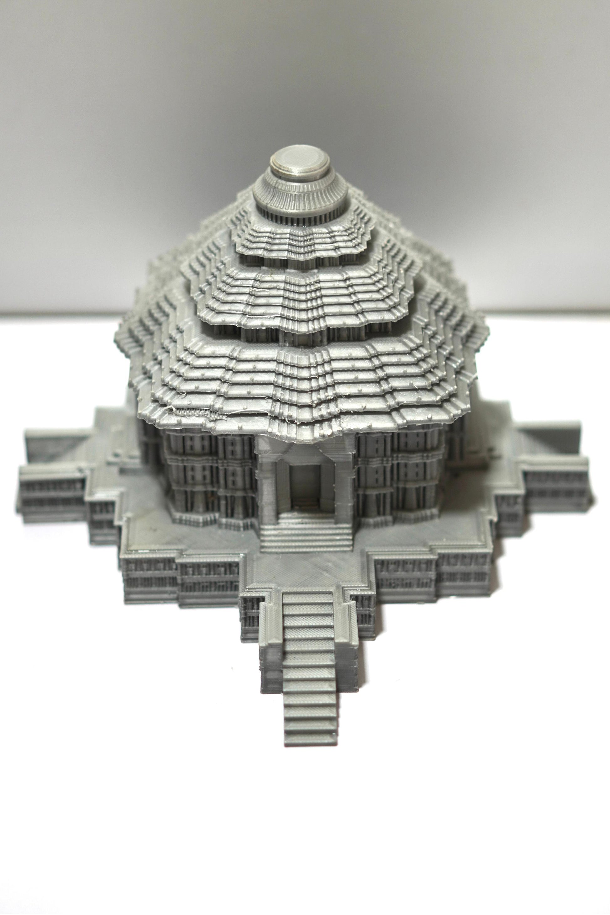 The Konark Sun Temple Sculpture is a 5.5-inch heritage architecture model, showcasing intricate gray multi-tiered domes and detailed steps, inspired by Indian temple design—displayed as a striking miniature on a white background.